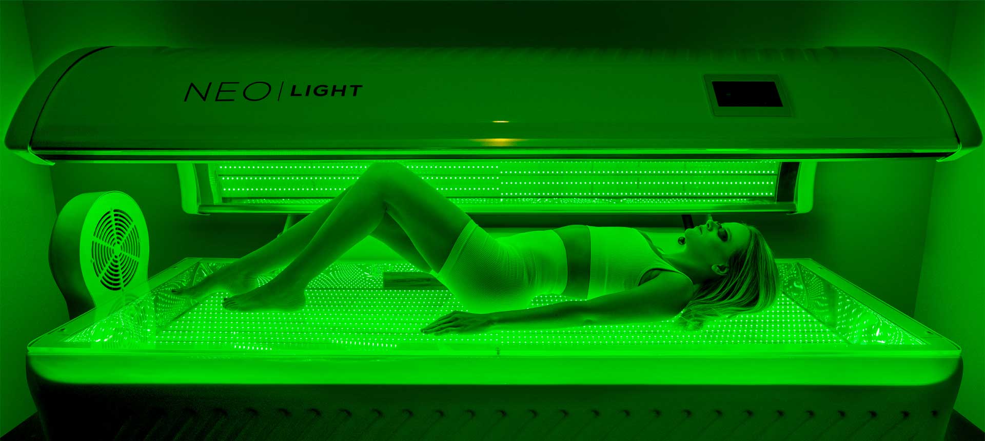 A woman laying on the ground in front of green lights.