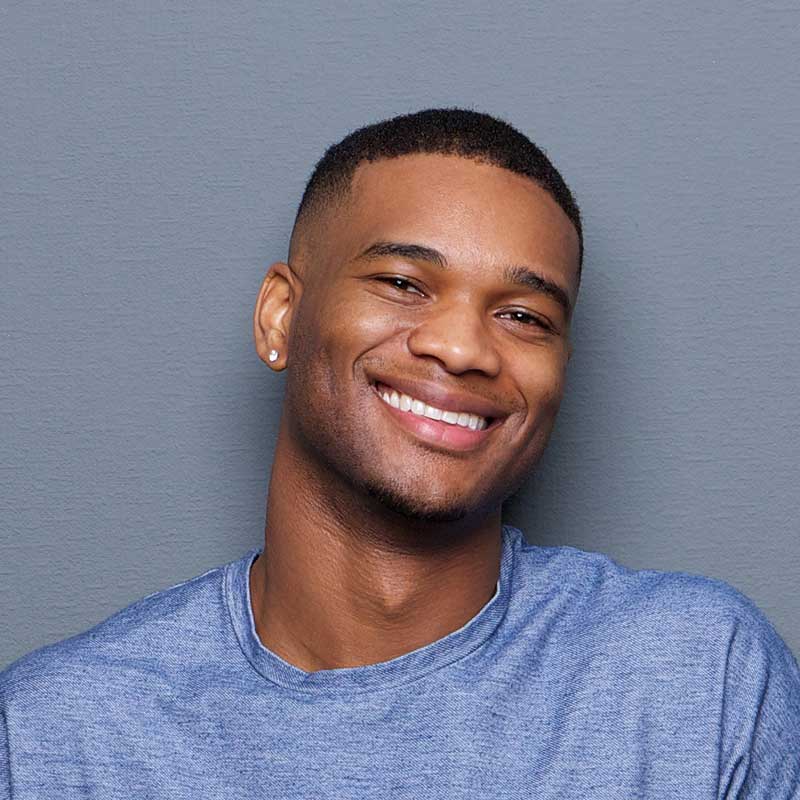 A man smiling for the camera with his teeth missing.