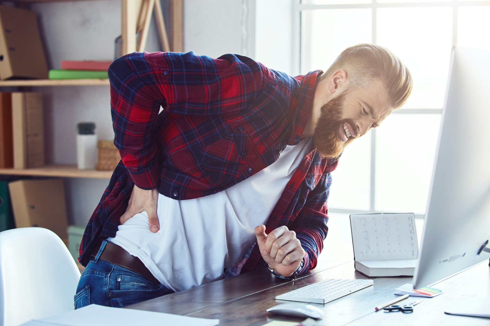 A man with a beard and plaid shirt on his back