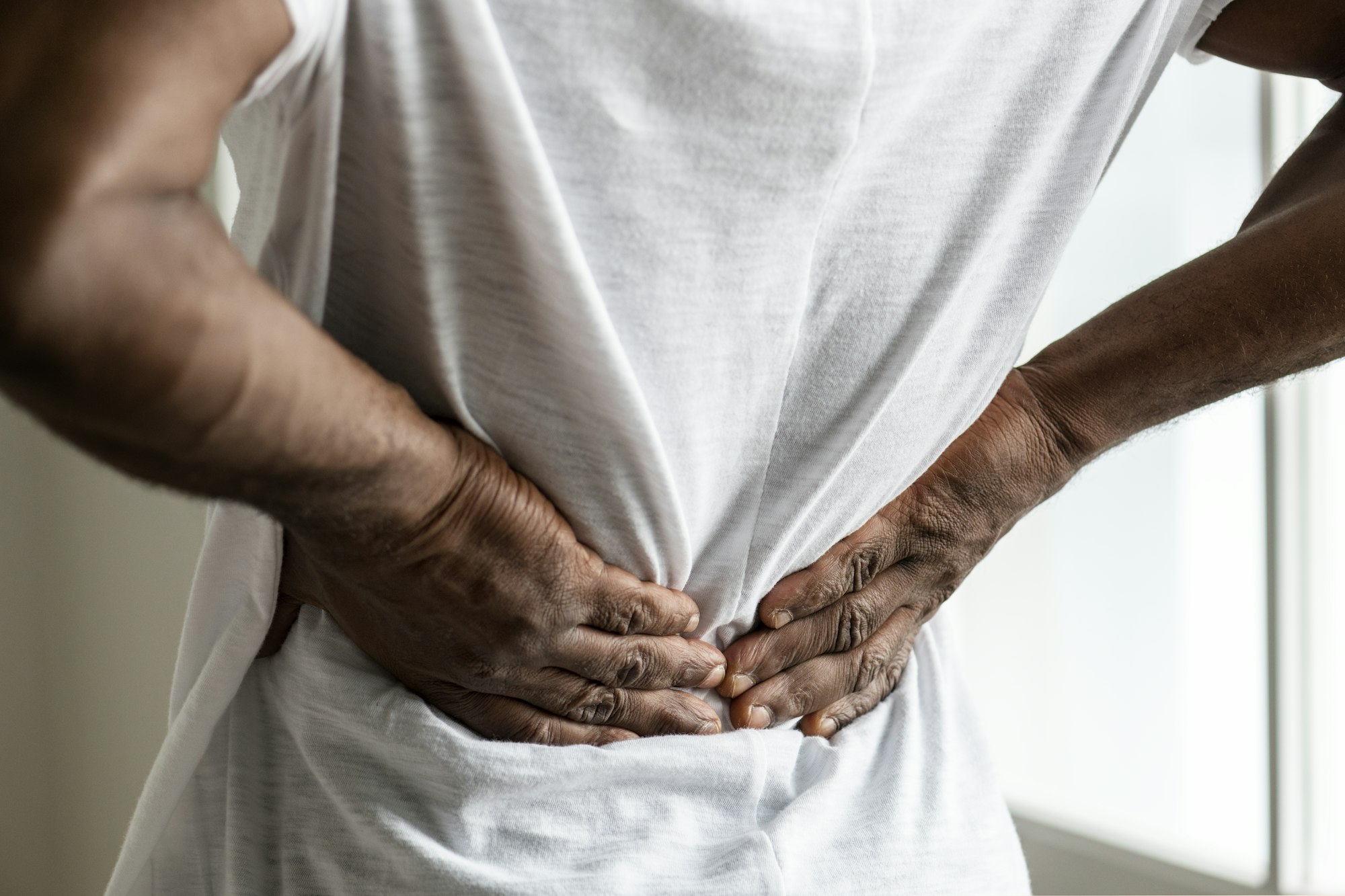 A person with their hands on the back of his body.