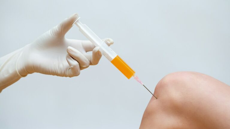 A person is holding an injection in his hand.