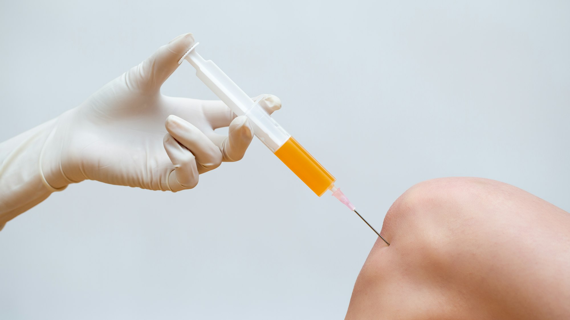 A person is holding an injection in his hand.