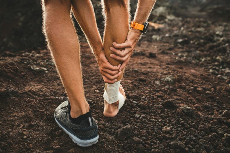 A person with a bandaged ankle is standing on the ground.