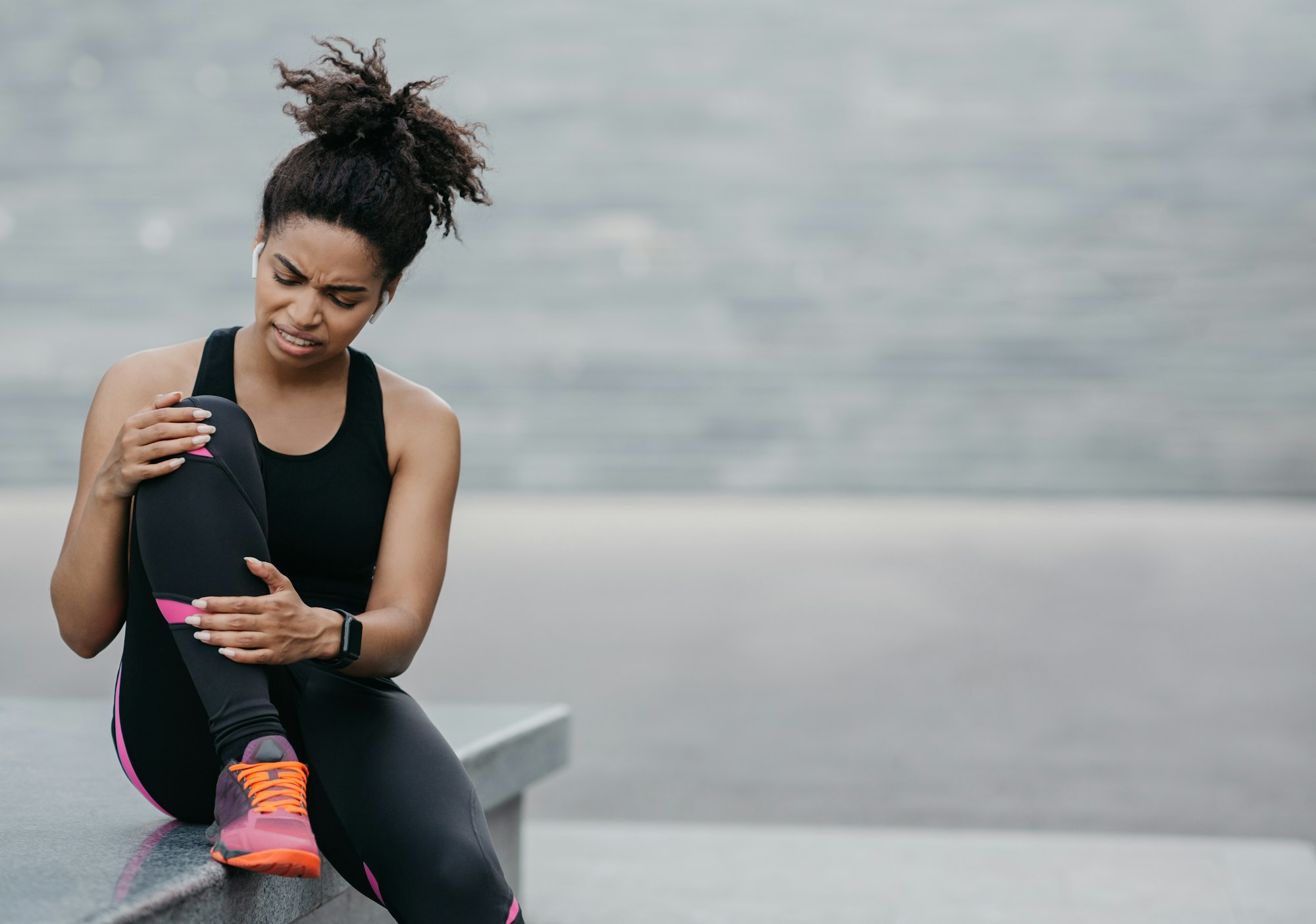 A woman sitting on top of a bench holding onto her phone.