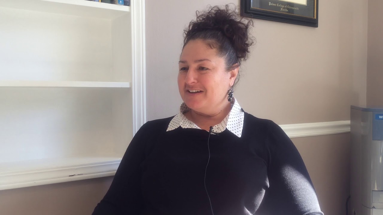 Woman in black shirt, smiling.